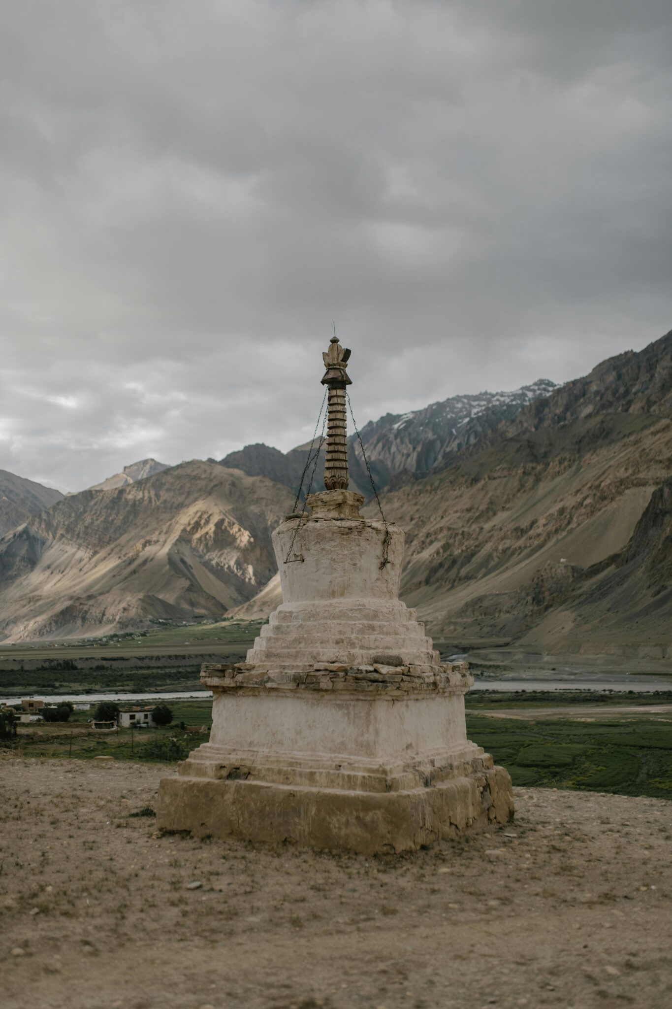 Old weathered chorten in historical Lamayuru Monastery located in mountainous valley in Ladakh against cloudy sky